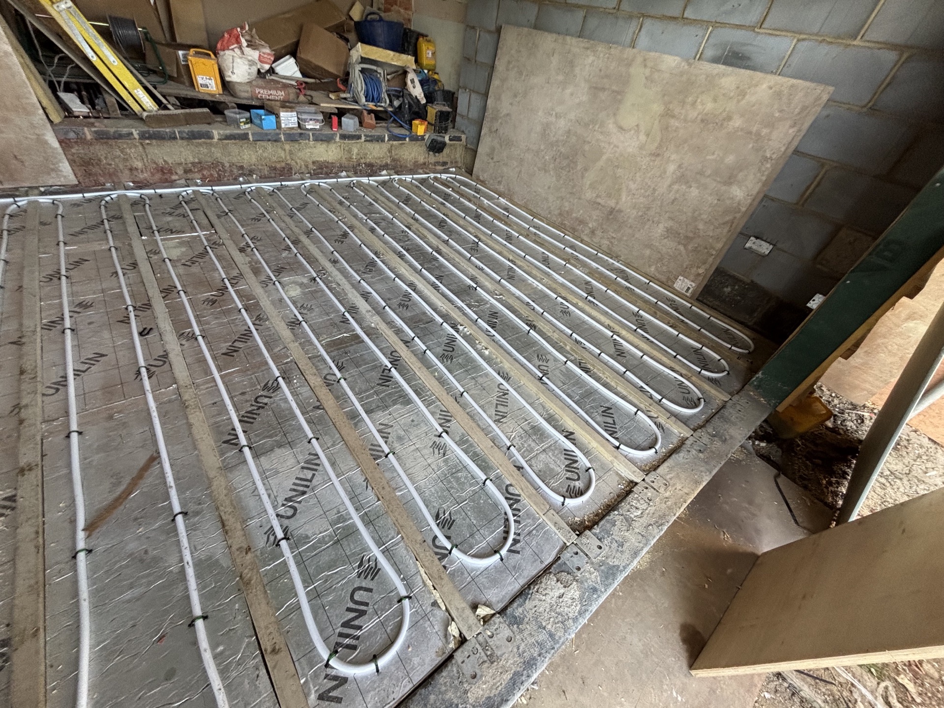 Grooved UNILIN heating deck with pipe and cement board ready to fix over